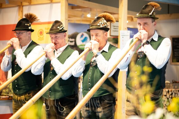 Vier Männer spielen Alphorn